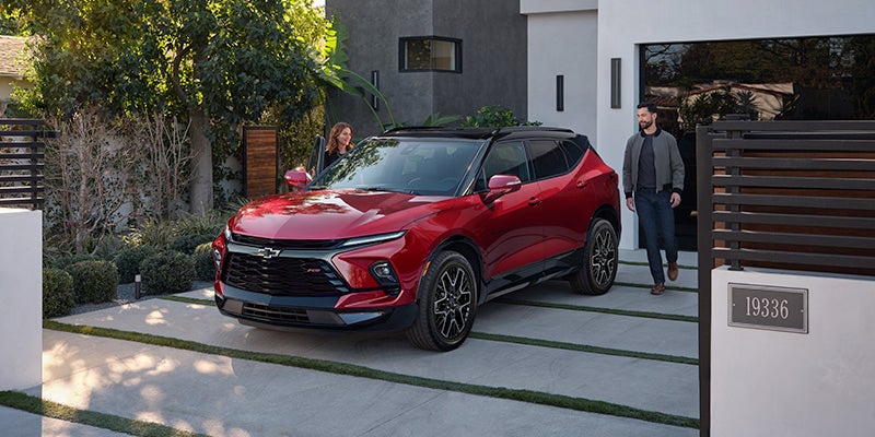 A man getting into a red 2024 Chevy Blazer
