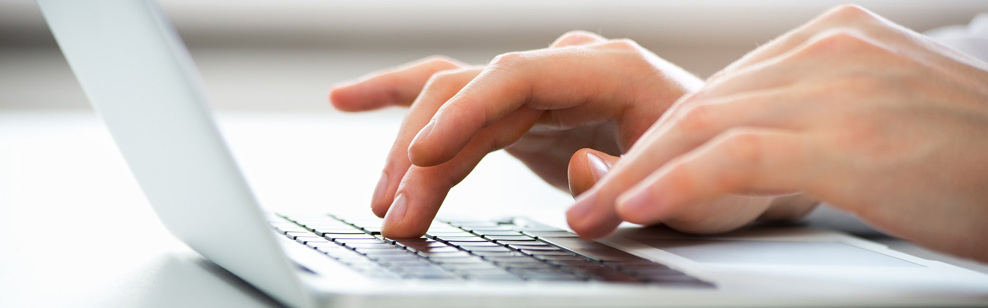 A person using a laptop to apply for financing for a used Chevy.