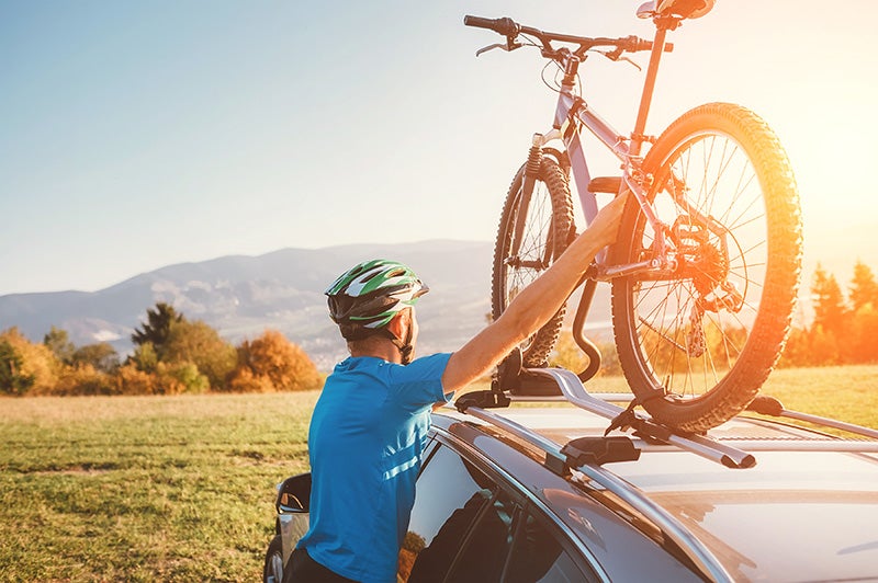 A bike being put on a bike rack on a vehicle