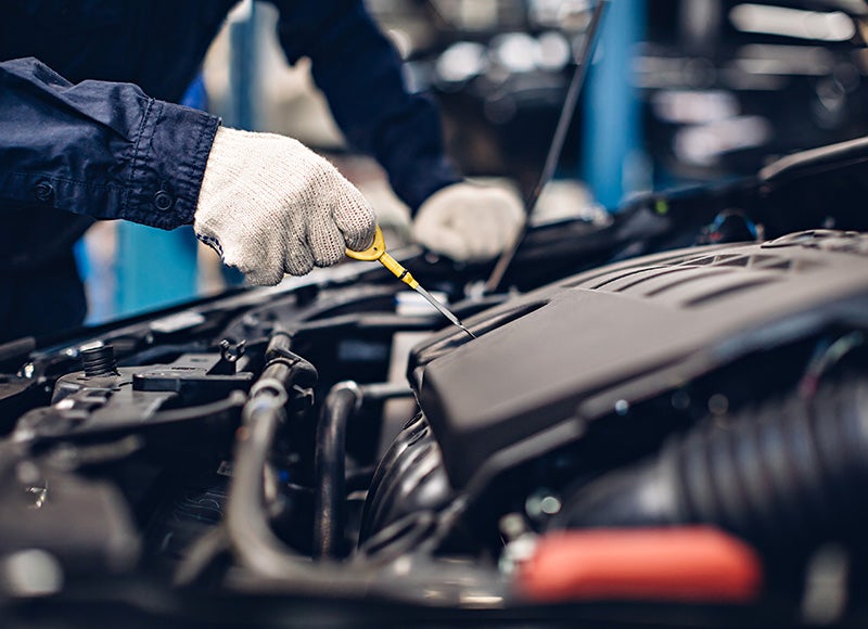 A service technician changing oil in a vehicle