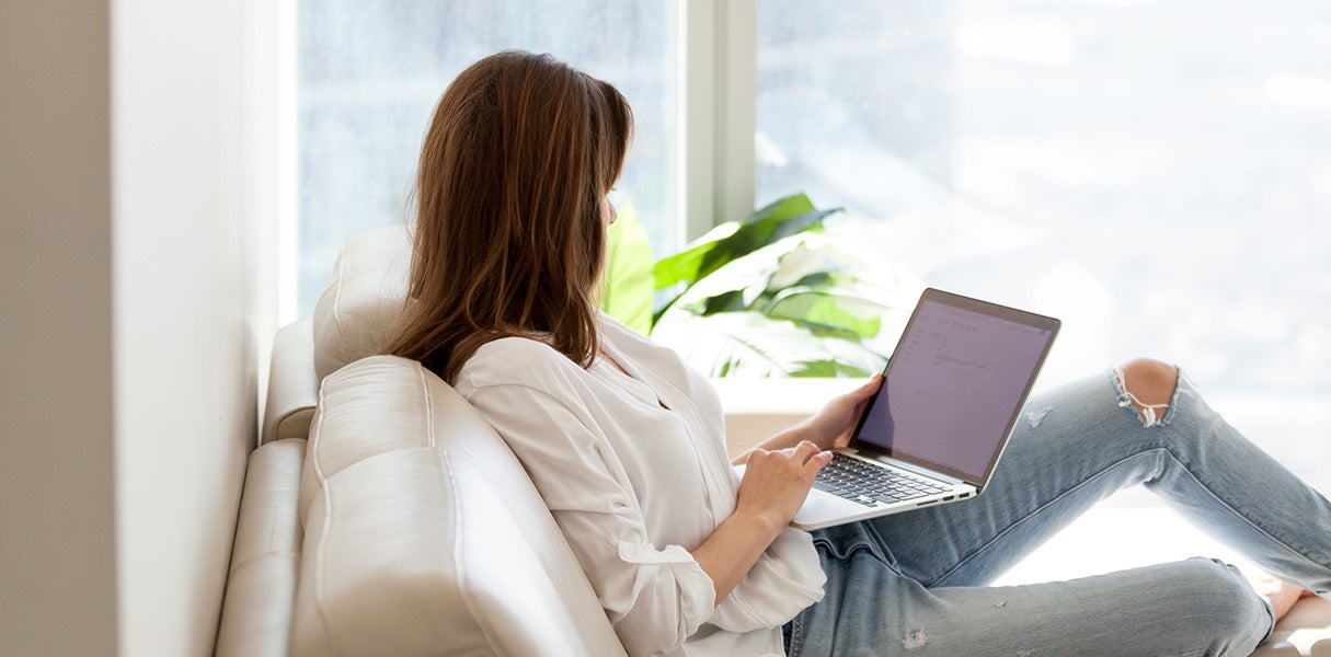 A woman on a couch scheduling service online